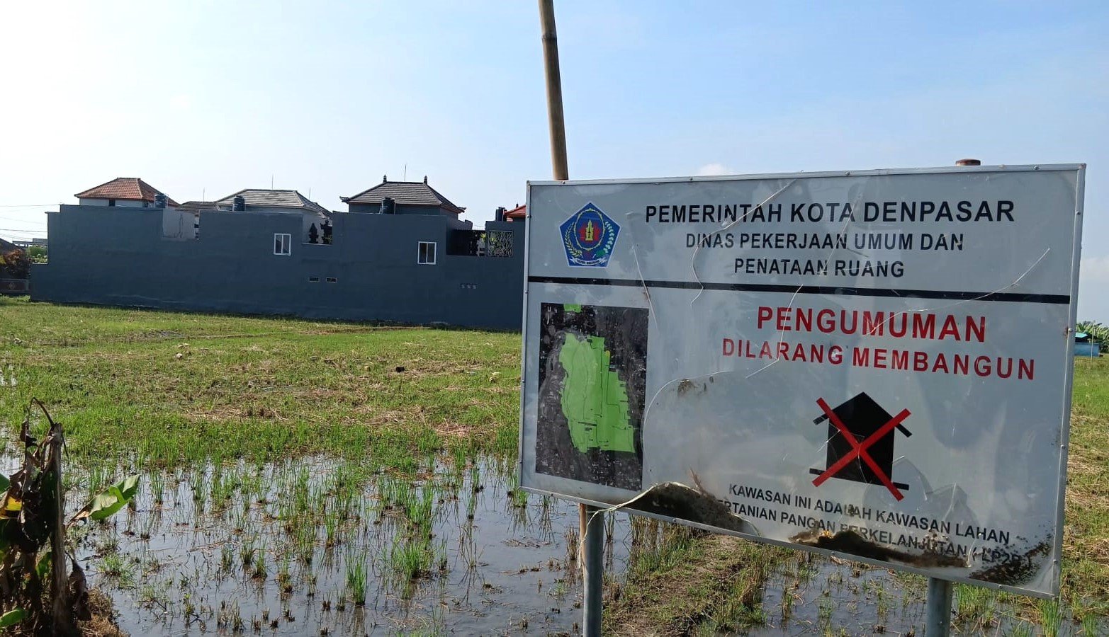 TAK ‘BERTARING’’ - Plang pengumuman dilarang membangun di wilayah Banjar Laplap di Jalan Siulan, Penatih Dangin Puri, Denpasar Timur, ini tak ‘’bertaring’’. Terbukti sejumlah bangunan bertingkat bercokol di belakang plang larangan itu tanpa ada dinas terkait yang memperhatikannya. Belakangan ini lahan sawah atau kawasan hijau produktif di Kota Denpasar jadi incaran untuk pembangunan perumahan. 
(BIG.com/ist)